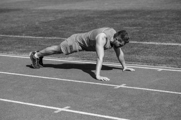 Musculoso chico de pie en la tabla haciendo empujar hacia arriba en el entrenamiento deportivo, entrenamiento — Foto de Stock