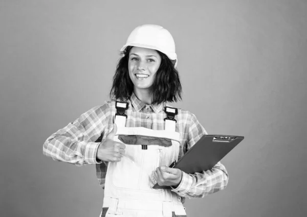 Счастливая женщина строитель в защитном шлеме использовать папку документа, инженер — стоковое фото