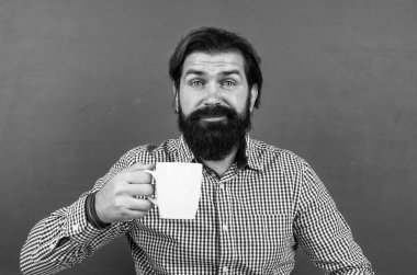 Gülümseyen hippi sabah kahvesini yeşil arka planda içiyor, uyan.