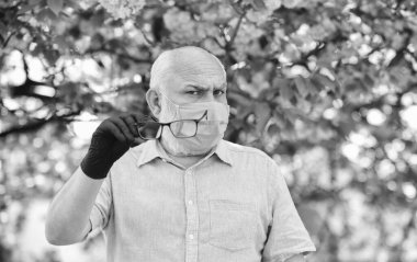 Salgın sırasında önlemlere dikkat edin. sağlıklı bir hayat. Çiçek açan pembe sakura parkında maske takın. Sakura 'daki koruyucu maskeli adam. Koronavirüs karantinasında çiçek kokusu alıyorum.