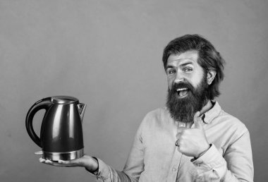 Bu en iyisi. Sakallı hippi ev aletleri kullanır. Mutfak konsepti Bıyıklı vahşi yakışıklı adam çay içiyor. Olgun koca elektrikli su ısıtıcısı tutar. Hayattaki modern teknoloji
