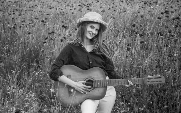양귀비 들판에서 기타와 음악을 하는 젊은 여자 — 스톡 사진