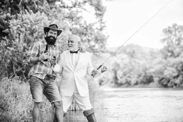 Picnic al aire libre. fin de semana familiar de verano. padre e hijo pescando. hombre maduro pescador celebrar la jubilación. dos pescadores con cañas de pescar. pasatiempo y actividad deportiva. hombre de negocios retirado. amistad masculina —  Fotos de Stock