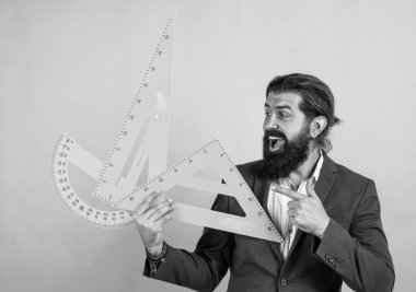 Ölçü ve boyut. Olgun öğretmenin elinde üçgen ve açıölçer varken mutlu ol. Sakallı adam mühendis cetvel ile çalışıyor. Geometri sınavına hazırlanın. Matematik dersi veren bir mimar ya da öğretim üyesi. Okula geri dön.