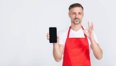 Önlüklü neşeli olgun bir adam akıllı telefona fotokopi alanı sunuyor. Tamam