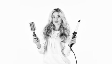 İhtiyaçlarınız için doğru saç maşasını seçin. Saç stili oluşturun. Uzun kıvırcık saçlı kadın saç maşası kullanıyor. Kuaför ipuçları. Sevimli sarışın kız. Çevrimiçi iş. Farklı paketleme teknikleri kullanarak