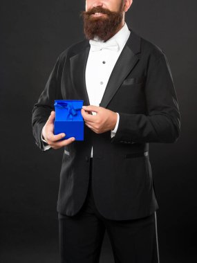 Smokinli gülümseyen adam siyah arka planda siyah papyonlu, kutulu. Sevgililer Günü