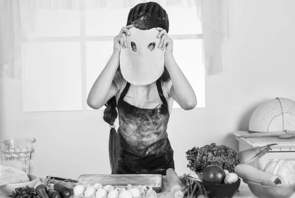 Malá holka peče v kuchyni. Kuchař vaří legrační těsto. dítě připravit zdravé jídlo doma a nosit kuchařskou uniformu. Úklid a domácí práce. vývoj v dětství — Stock fotografie