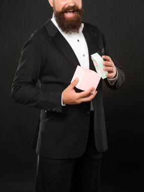 Smokinli, papyon takan, siyah arka planda, kutulu mutlu bir adam. Sevgililer Günü