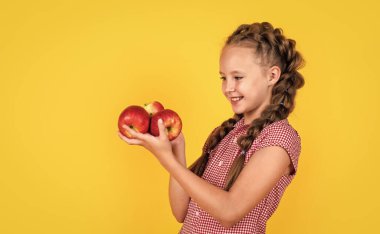 Şuna bir bak. Vitamin dolu. Gülümseyen çocuk kırmızı elmayı tutuyor. Vejetaryen diyeti. Sonbahar hasadı.