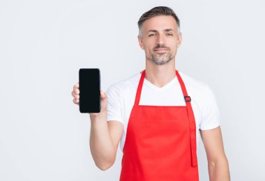 Önlüklü gülümseyen olgun bir adam akıllı telefona fotokopi alanı sunuyor.