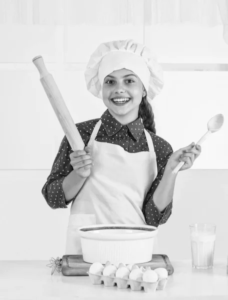 Pastelaria caseira. infância feliz. feliz adolescente menina cozinhando massa. criança em uniforme de chef. — Fotografia de Stock