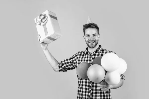 Joven guapo hombre en camisa a cuadros celebrar fiesta globos y presente caja, día de fiesta — Foto de Stock