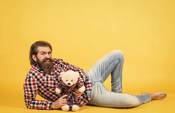 Caucasiano maduro hipster com penteado na moda em xadrez camiseta segurar ursinho brinquedo, compras — Fotografia de Stock
