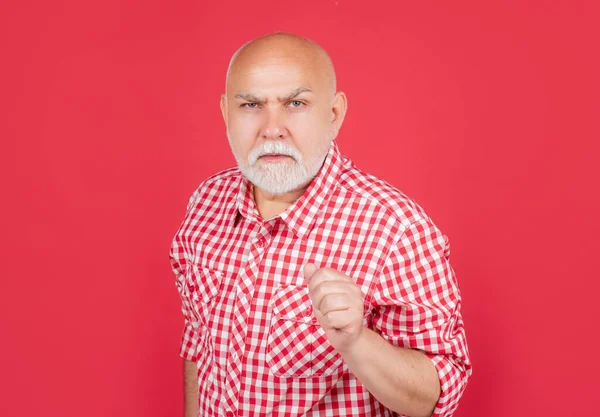 Surowy stary mężczyzna w kratkę koszula na czerwonym tle — Zdjęcie stockowe