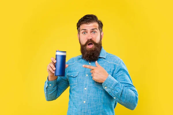 Sorpreso brutale barbuto punto dito uomo sulla bottiglia condizionatore di capelli su sfondo giallo, skincare — Foto Stock