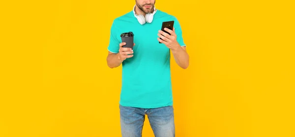 Cropped guy check sms on phone with coffee on yellow background, communication — ストック写真