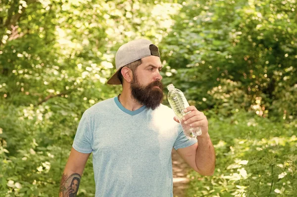 Érett szakállas férfi nyári ruhák inni vizes palack erdőben, hidratáció — Stock Fotó