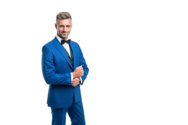 Mavi smokinli gülümseyen resmi adam beyaz arka planda izole edilmiş.