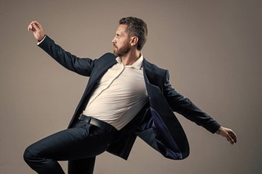 Mutlu iş adamı resmi takım elbise giyip ofiste dans ederek şirket partisini ve mutluluğu kutluyor.