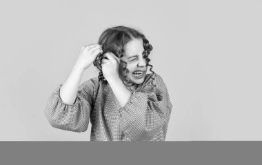 Parlak buklelerin tadını çıkarıyorum. Şekil vermek için yağ kremi. Kuaför malzemeleri. Parti için saç stili. Güzel, sağlıklı saçlar. Moda ve güzellik. Küçük kız kuaför salonu. Küçük kıvırcık saçlı çocuk