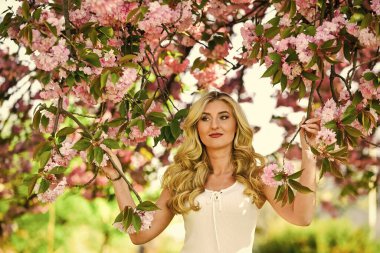 Bahar çiçeği açan ağaç. Mutlu bahar günleri. Kız bahçede sakura çiçeğinin tadını çıkarıyor. Kiraz ağacı. Çiçek aroması. Uyum ve kadın enerjisi. Bahar sembolü Çiçeklerin kadınları neden her zaman mutlu ettiğini.
