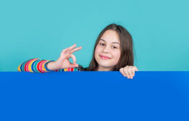 Boş mavi kağıdın arkasında reklam için fotokopi alanı olan mutlu çocuk.