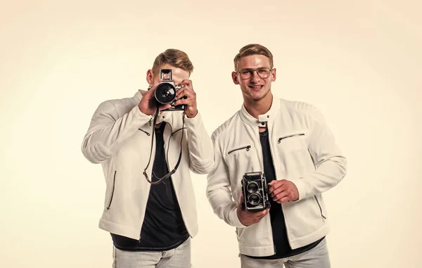 twin brothers men photographer in white casual look alike use vintage photo camera, photographing.