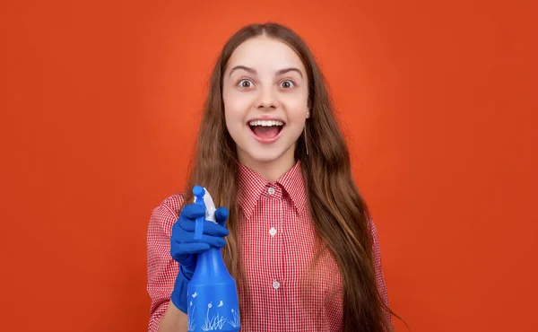 Erstauntes Kind in Gummihandschuhen mit Sprühflasche auf rotem Hintergrund — Stockfoto