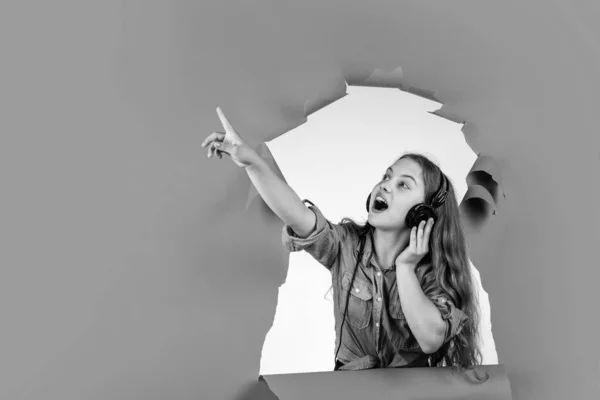 Olha para ali. aprendizagem electrónica na escola. menina adolescente feliz ouvir música em fones de ouvido. — Fotografia de Stock