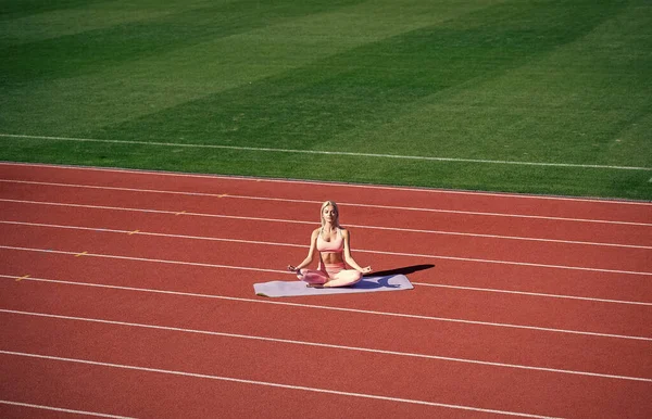 Fit dame in fitness dragen mediteren op het stadion na sport workout, yoga — Stockfoto