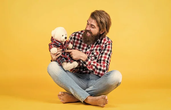 Brutal barbudo homem desgaste xadrez camisa ter exuberante barba e bigode com ursinho de pelúcia brinquedo, dia dos namorados — Fotografia de Stock