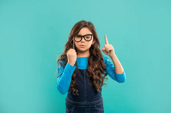 Ernsthafte Teenager-Mädchen mit Idee inspiriert hat lockiges Haar halten Partei Zubehör der Brille, Party — Stockfoto