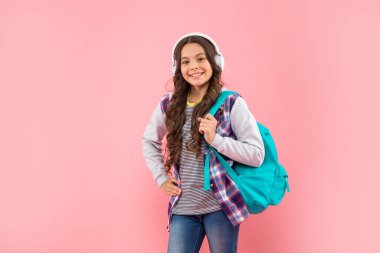 Okula dönüyorum. Kulaklıklı neşeli genç kız. Müzik dinle. kablosuz kulaklık aygıtı aksesuarı