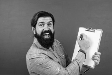 Sakallı ve bıyıklı yakışıklı adam not almak, kopyalamak ve proje yapmak için belge kağıdı gösteriyor.