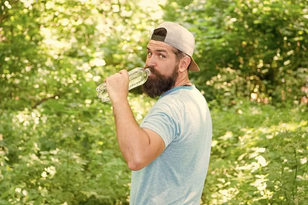 Dagligt vatten. brutal skäggig man dricka flaska. mogen hipster med skägg i skogen. — Stockfoto