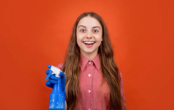 Happy amazed child in rubber gloves with spray bottle on red background — Stok Foto