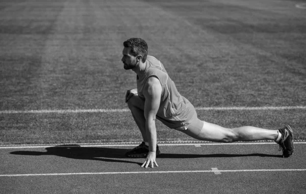 Pokračuj. sportovec v klidu. sportovec trénuje svou flexibilitu. být flexibilní. muž dělá tělocvik na stadionu. posilovna venkovní. svalnatý atletický trénink. sport. mužské napjaté svaly — Stock fotografie