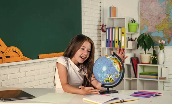 Šťastný dítě dívka studovat zeměpis se zeměkoulí ve škole, učení — Stock fotografie