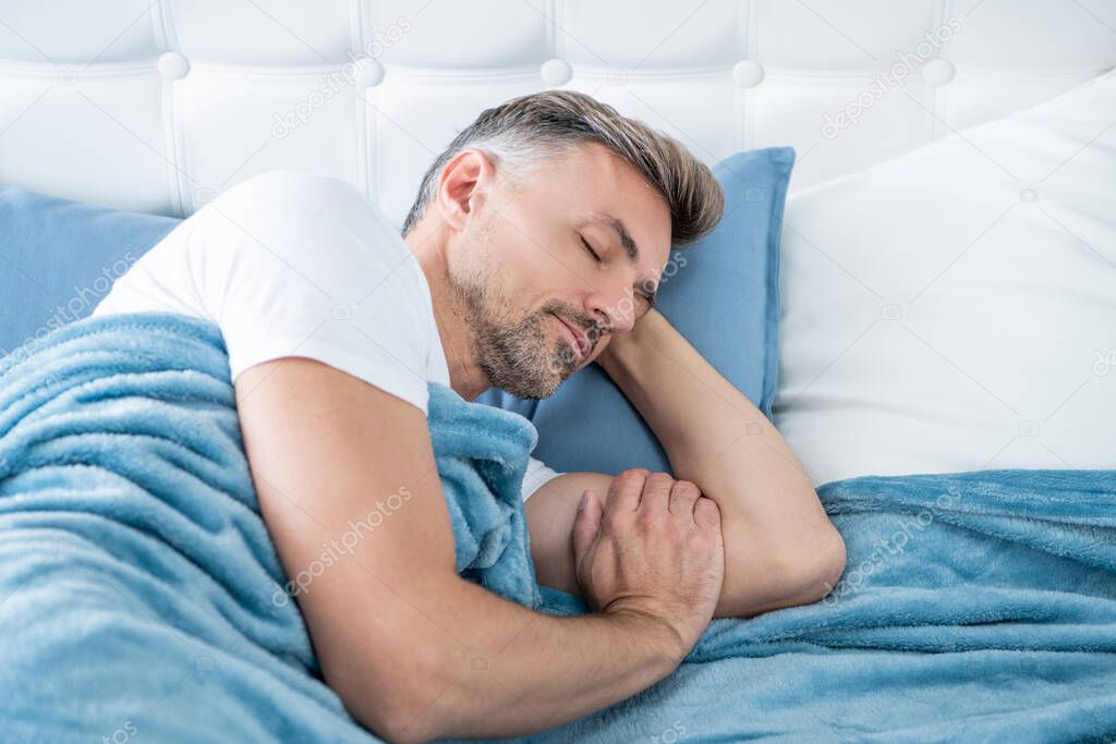 grizzled man sleeping in bed. early morning