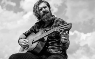 Benim dünyam burası. Olgun karizmatik erkek gitarist. Sakallı ve bıyıklı adam gitar çalıyor. Kareli gömlekli sakallı adam şarkı söylüyor. Müzisyen müzisyen. müzik teli enstrümanı