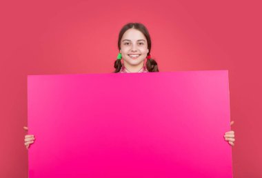 happy child hold blank pink paper with copy space for advertisement