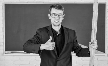 Matematik ve insanlar kavramı. Tahtadaki adam. Okula dönüyorum. Bilgiye doğru. Geometri favori konusu. Erkek öğretmen matematik cetvelini tutuyor. Eğitim ve okul konsepti. kök okul disiplinleri