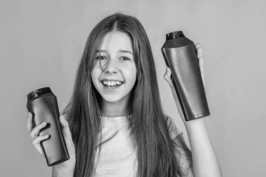 Sevimli kız çocuğunun moda bir saç stili var ve şişede losyon kullan, güzellik alışverişi.