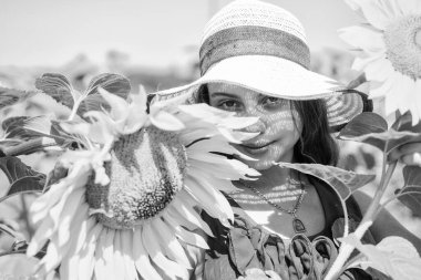 Ayçiçeklerinin arkasına saklanan küçük kırsal bir kız, neşeli bir ruh hali.