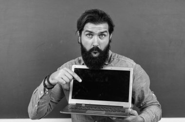 Bilgisayarda çalışan yetişkin bir öğretmene şaşırdım. Sınıfta dizüstü bilgisayarlı kaba sakallı bir adam çalışıyor. Online sınav için hazırlanın. Özel ders üzerine üniversite hocası. Okula dönüyorum. çevrimiçi kayıtdışı eğitim