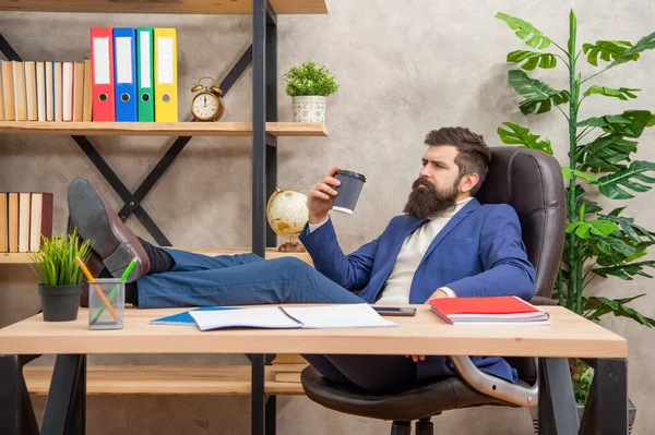 Tired man in suit relaxing with legs on desk during coffee break in office, relaxation —  Fotos de Stock