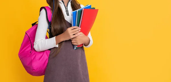 Mosolygós gyermek fülhallgató iskolai hátizsák munkafüzet sárga háttér — Stock Fotó