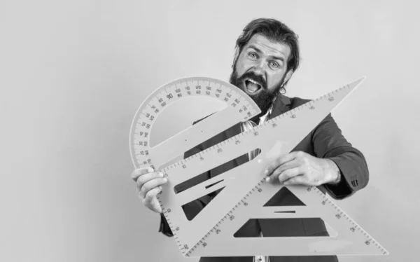 Passa no exame de matemática. aprender o assunto. homem feliz com barba usando triângulo e transferidor. estudando a medição. educação formal. Estudante do sexo masculino na aula de matemática. espaço de cópia — Fotografia de Stock