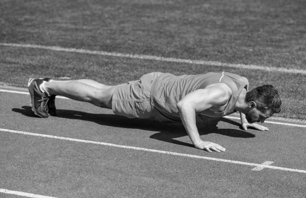 Μυώδης άνθρωπος σταθεί σε σανίδα κάνοντας push up για την προπόνηση του αθλητισμού, την ενέργεια — Φωτογραφία Αρχείου